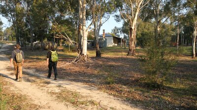 2 people walking on track in Australian bush to heritage property