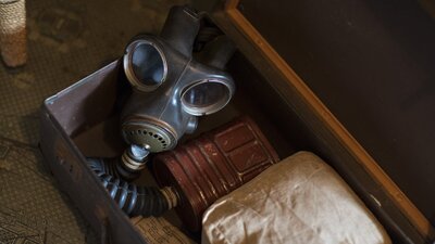 An open suitcase containing a WWII gas mask