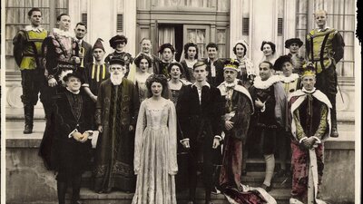 group of 20 people standing outside dressed in classical Shakespearean costume