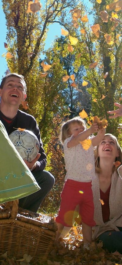 Family playing in the Autumn leaves