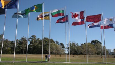 Couple walking underneath international flags