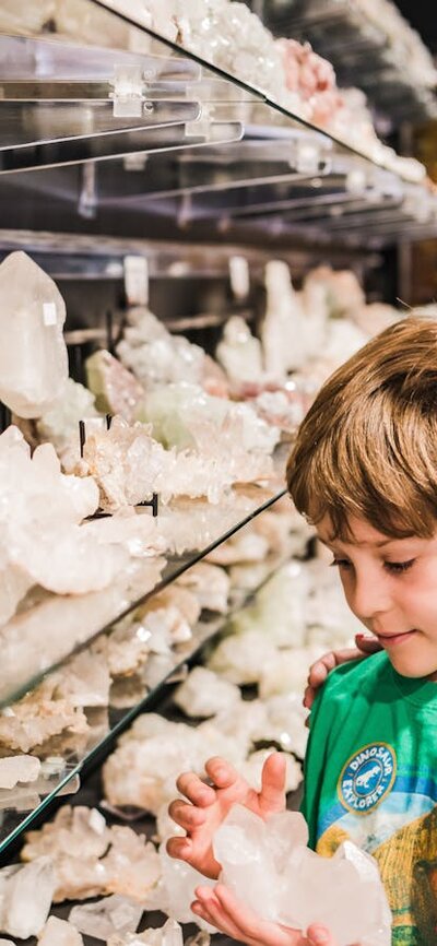 Little boy looks at clear quartz with Auntie