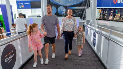 family of 4 walk up the Questacon ramp by the ticket desk