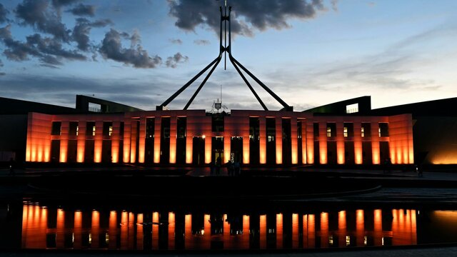 Australian Parliament House at dusk with an orange illumination