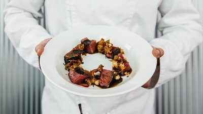Chef holding a beautiful dish made with truffles