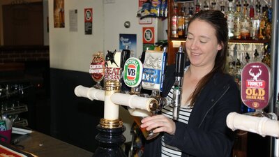 Girl pouring a beer at the bar