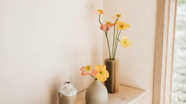 Interior of Dinny, the tiny home. A cosy corner stocked with local ceramics. Floating desk in Dinny, the tiny home. Perfect spot for a coffee, reading book or a glass of wine