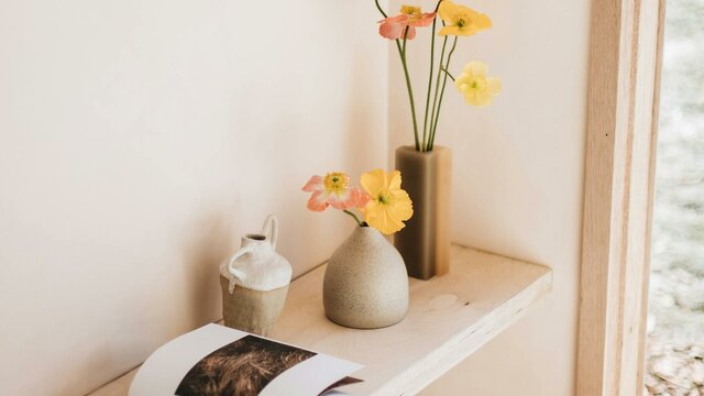 Interior of Dinny, the tiny home. A cosy corner stocked with local ceramics. Floating desk in Dinny, the tiny home. Perfect spot for a coffee, reading book or a glass of wine