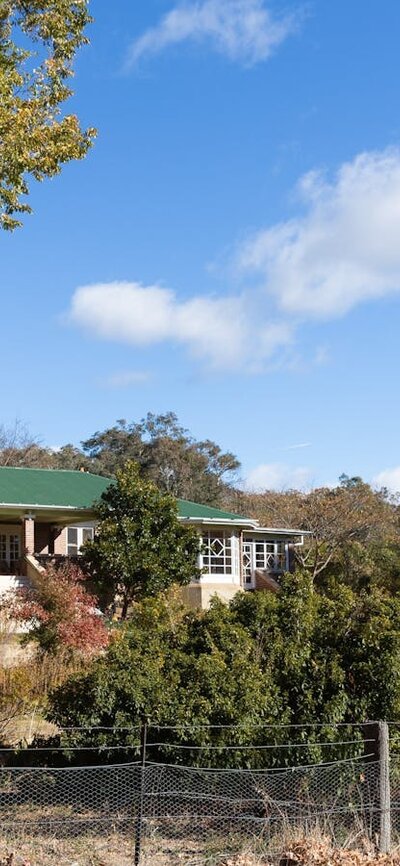 view of a heritage listed homestead amidst an autumnal garden