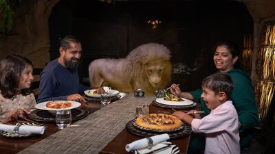 Family dining in Cave Restaurant with Jake the white lion.