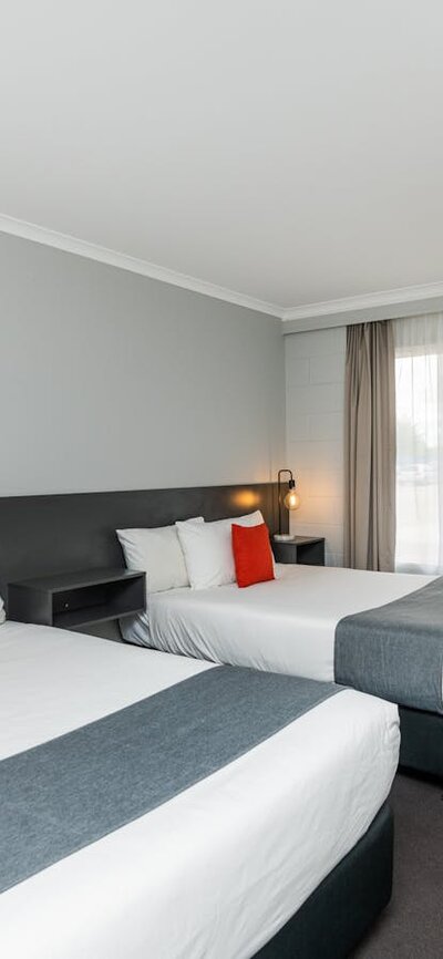 Twin Double Room layout, featuring two double beds, desk, kitchenette and modern design.