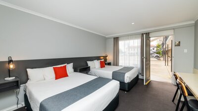 Twin Double Room layout, featuring two double beds, desk, kitchenette and modern design.