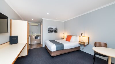 Living area and bedding of River Motel's Queen Room