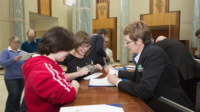 Image of a Visitor Services Officer assisting visitors to Parliament House