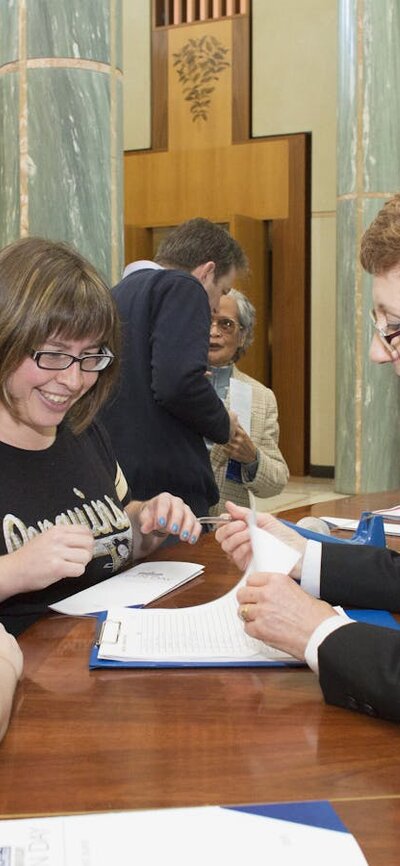 Image of a Visitor Services Officer assisting visitors to Parliament House