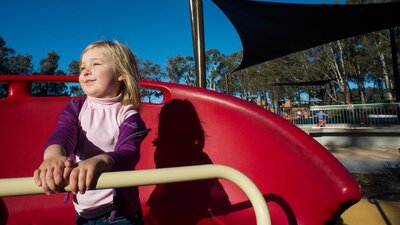 Girl on a spinning piece of play equipment in the Boundless Playground