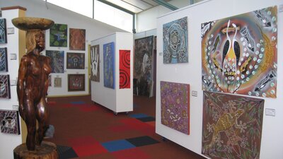 Artwork displayed on movable walls near the rear of the gallery
