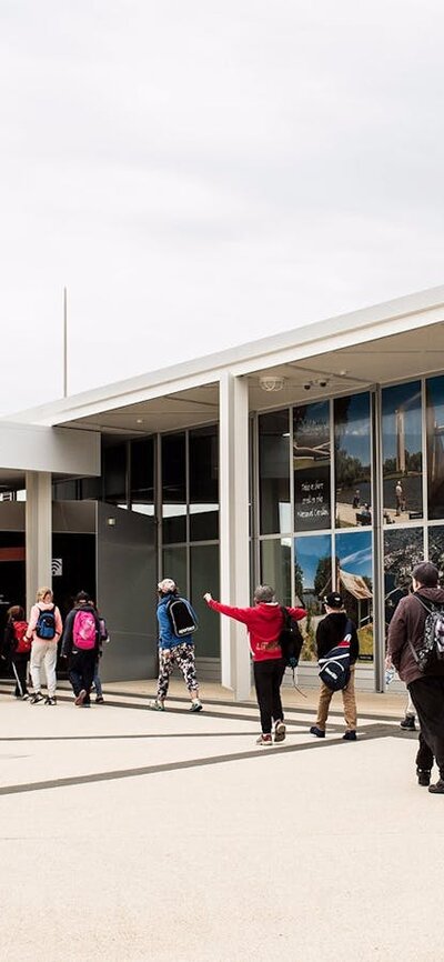 Canberra and Region Visitors Centre, next to The Deck cafe and the National Capital Exhibition Group of school children arriving at the Canberra and Region Visitors Centre