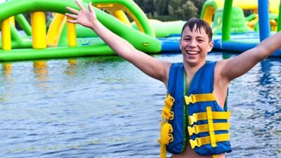 Child at waterpark with arms in the air