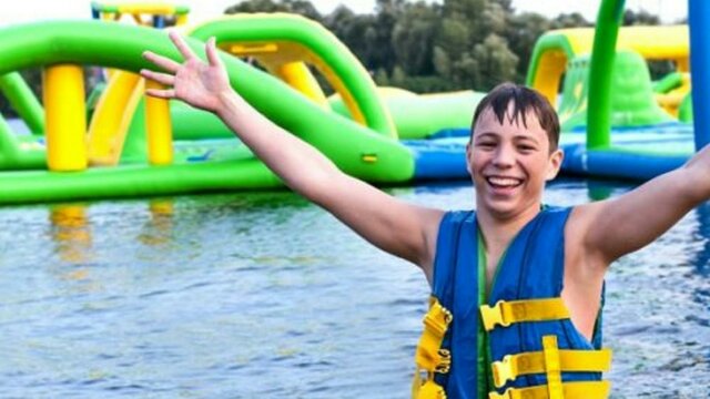Child at waterpark with arms in the air