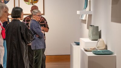 People observing Hiroe Swen's ceramics at Canberra Museum + Gallery