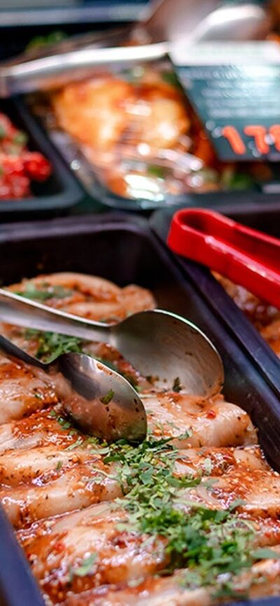Trays of chicken with tongs