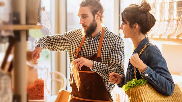 Man wearing checkered shirt serving lady wearing denim jacket