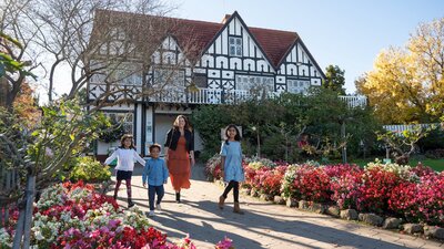 Family walks in front of a Tudor style architecture buidling