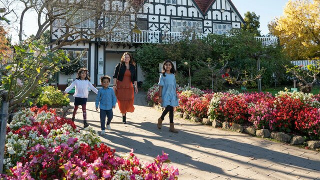 Family walks in front of a Tudor style architecture buidling