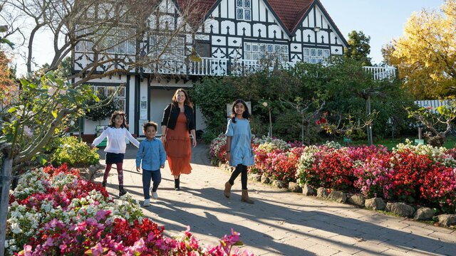 Family walks in front of a Tudor style architecture buidling Family walks in front of a Tudor style architecture buidling