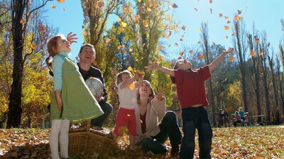 Family playing in the Autumn leaves