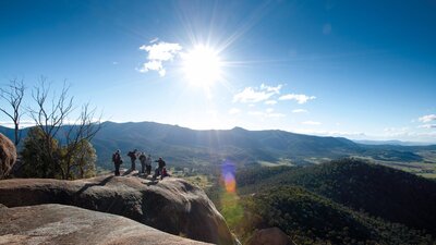 Small group of people looking out over magnificent views of the valley and mountain ranges