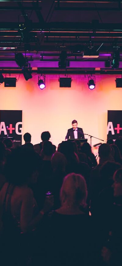 An event in the Main Hall at the Ainslie Arts Centre. Large crowd of people turned towards the stage