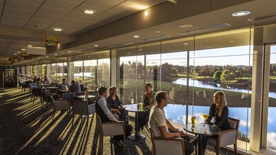 People enjoying drinks overlooking the lakes and golf course