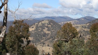 Three hikers on a trail looking at the views from Mt  Tennent in Namadgi National Park