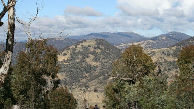 Views from Mt Tennent in Namadgi National Park Three hikers on a trail looking at the views from Mt Tennent in Namadgi National Park