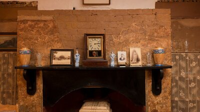 Fireplace in Mugga-Mugga cottage with historical photographs and objects