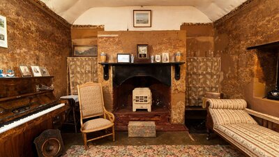Fireplace in Mugga-Mugga cottage with historical photographs and objects