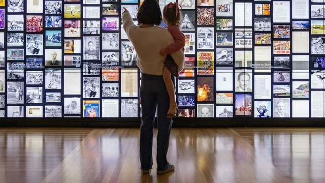 Visitors pointing at interactive digital wall.
