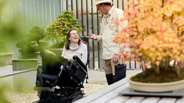 Volunteer guide talking with visitor in a wheelchair