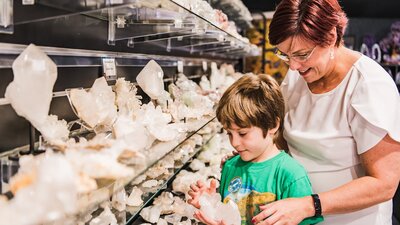 Little boy looks at clear quartz with Auntie