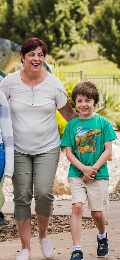 Teenage girl, Auntie and little boy strolling in the Dinosaur Garden