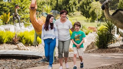 Teenage girl, Auntie and little boy strolling in the Dinosaur Garden