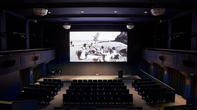 Arc Cinema with archival black and white footage on the screen