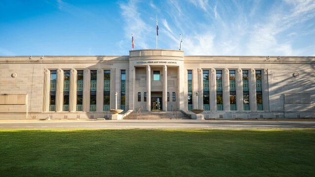 The National Film and Sound Archive of Australia Front of heritage building with green lawn in front and blue sky