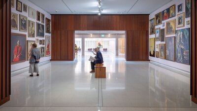 A photograph of Gallery 1 space featuring a salon hang of paintings