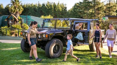 Family and zoo guide with a Hummer, a vehicle used for night tours within the national zoo