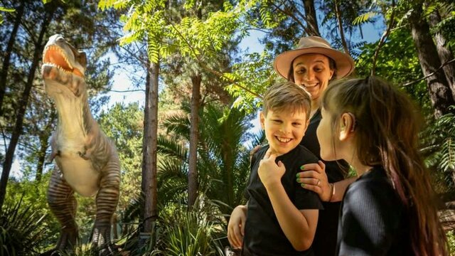 National Zoo & Aquarium Canberra a dinasaur and a family smiling at the National Zoo & Aquarium Canberra