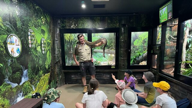 Snake Demonstration at the National Zoo An educator showing a large Burmese python to a group of students.