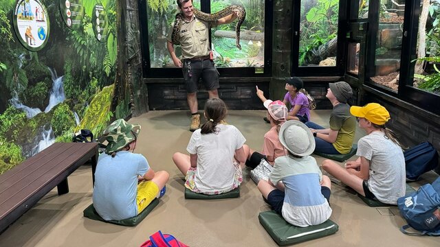 Snake Demonstration at the National Zoo An educator showing a large Burmese python to a group of students.